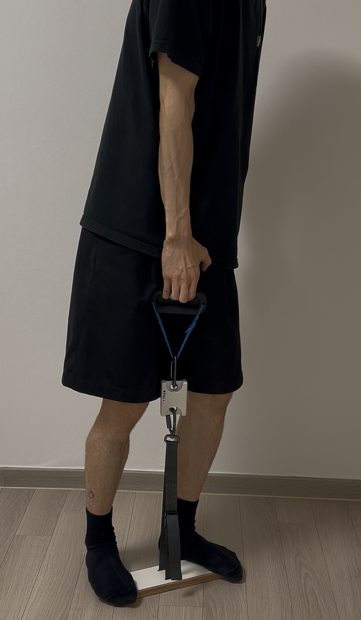 Side view of a person standing on the footplate and pulling a Frez handle with one hand